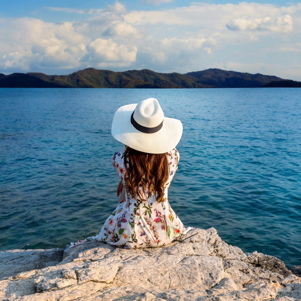 Best months to visit Turkey? - Summer in Turkey, a woman sitting on a rock enjoying the view of the sea